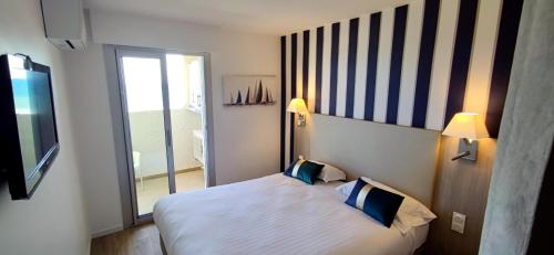 鲁西隆地区卡内Belle Vue Mer Canet Plage accès piscine couverte et chauffée的酒店客房设有一张床和一个大窗户