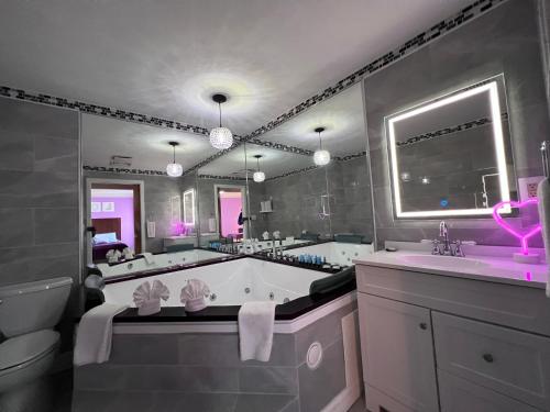 萨默塞特Orbits Inn的一间带浴缸和大镜子的浴室
