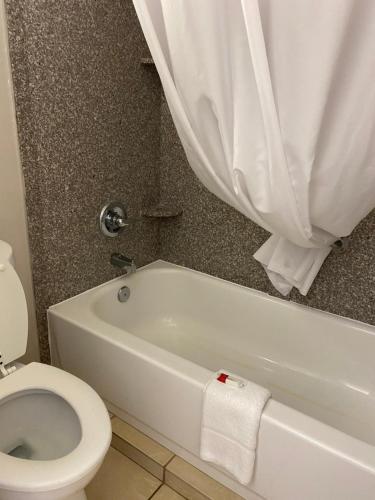 布伦瑞克布伦瑞克戴斯酒店的浴室配有卫生间和白色浴缸。