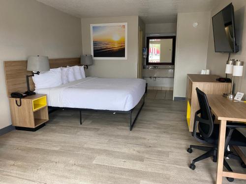 布伦瑞克布伦瑞克戴斯酒店的酒店客房配有一张床、一张书桌和一台电脑