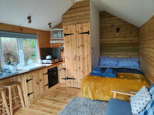 兰代洛Dryw bach glamping hut的一间带床的小卧室和一间厨房
