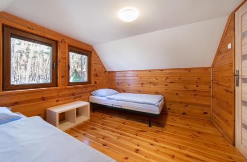 LubiatówSława Family Resort的一间设有两张床的房间,内设一张长凳