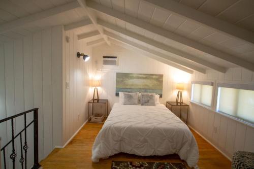 洛杉矶Peaceful Getaway in Studio City的一间卧室配有一张带白色床单和两盏灯的床。