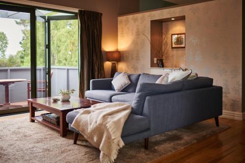 马丁伯勒Parehua Resort的客厅配有蓝色的沙发和桌子
