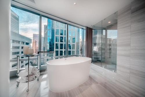 温哥华Paradox Hotel Vancouver的带浴缸和大窗户的大浴室
