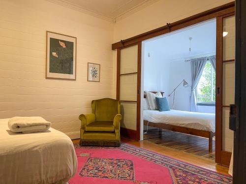 滕特菲尔德Blue Duck Cottage Village Comfort with Fireplace的卧室配有床、椅子和窗户。