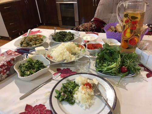 GarniGuest House SAMAN的餐桌,盘子上放着食物和蔬菜碗