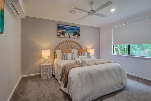 麦夸里港Coastal 3-bedroom home close by the beach的一间卧室配有一张带两盏灯的床和一扇窗户。
