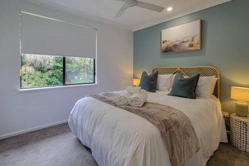 麦夸里港Coastal 3-bedroom home close by the beach的一间卧室设有一张大床和一个窗户。