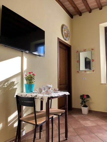 锡耶纳La Casina Verde的一张桌子、椅子和墙上的电视