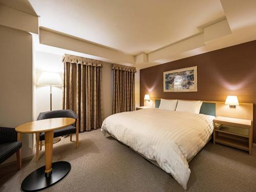 宇都宫宇都宫东武格兰德酒店的酒店客房,配有一张床、一张桌子和椅子