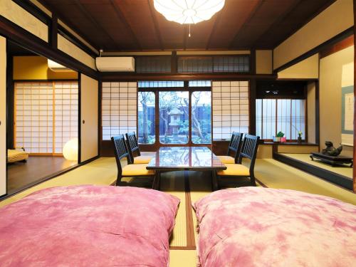 京都Ryokan Tanoya的一间设有两把椅子和一张桌子的房间,窗户
