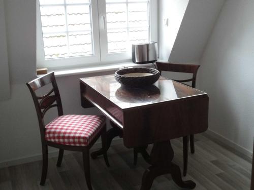 卡珀尔恩Ferienwohnung Hansen in Hafennähe的餐桌,两把椅子和碗