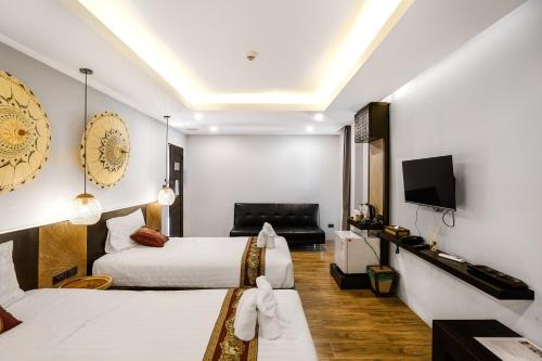 清迈Paraiso Hotel Chiangmai的酒店客房设有两张床和一台平面电视。
