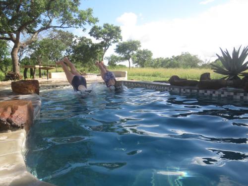 姆巴巴内Mkhiweni Villa at Dombeya Wildlife Estate的两人在水池游泳