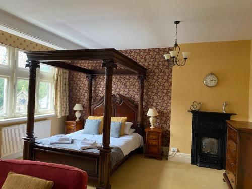 马特洛克巴玲顿旅馆的一间卧室设有一张天蓬床和一个壁炉