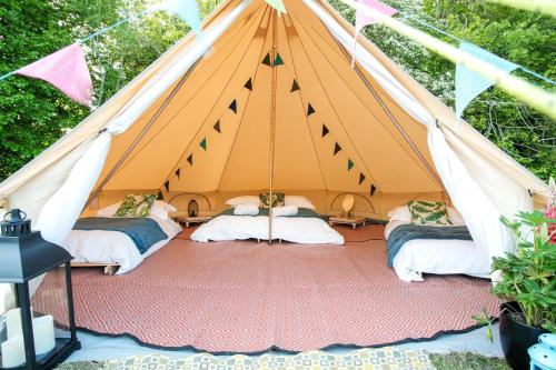 瓦伊河畔海伊Glamping at Hay Festival的帐篷内有3张带旗帜的床