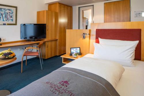 代特莫尔德Residenz Hotel Detmold的一间酒店客房,配有一张床和一台电视