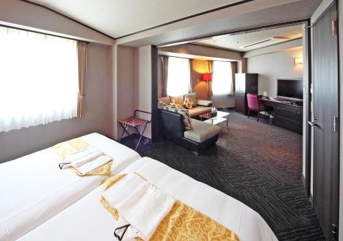 堺市萨凯太阳广场酒店的酒店客房设有一张大床和一间客厅。
