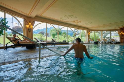 奥伯斯特多夫舒尔康体SPA度假酒店 - 仅限成年人的坐在酒店游泳池里的男人