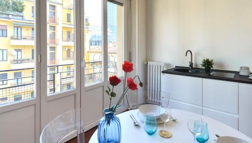 米兰Milanoverse Apartment的一间带桌子和窗户的用餐室
