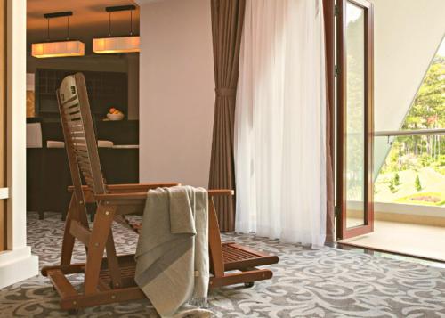 大叻瑞士伯莱索特宣林度假村的一间设有两把椅子、一张桌子和一个窗户的房间