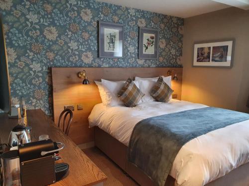 斯基普顿Old Swan的酒店客房配有一张床铺和一张桌子。