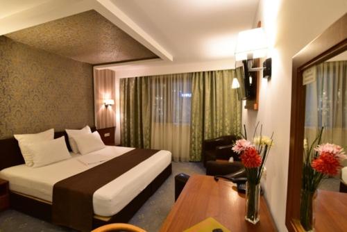 普洛耶什蒂弗洛姆酒店的酒店客房配有一张床铺和一张桌子。