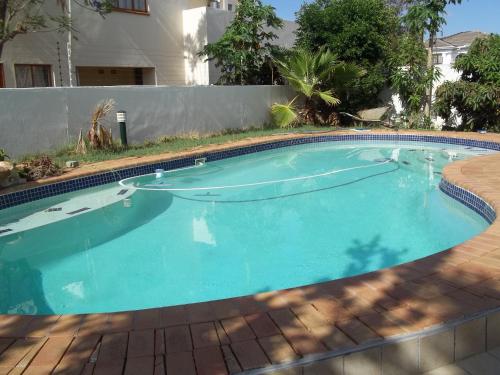 哈博罗内Carlcyn Homestay的庭院里的一个蓝色海水大型游泳池