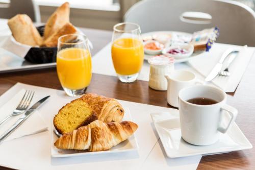 孔夫朗-圣奥诺里讷钟楼康弗兰圣奥诺丽娜酒店的一张桌子,早餐包括羊角面包和橙汁