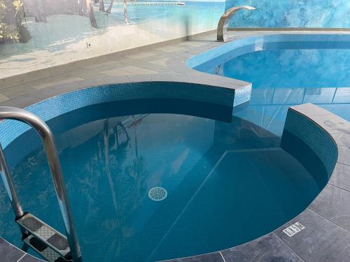 AizkraukleVILARHOTEL的蓝色的游泳池,里面设有长凳