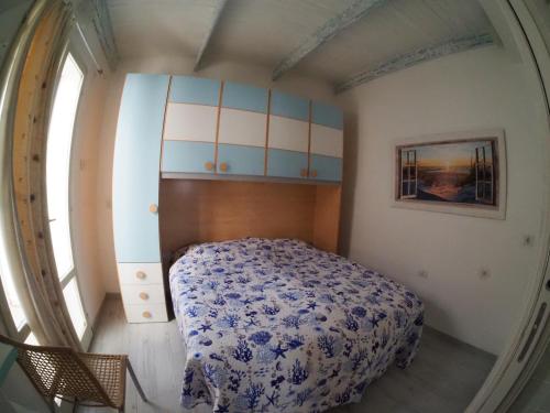 卡拉赛达Perla del mare的一间卧室配有一张带蓝白色毯子的床