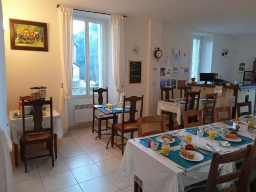 Villeneuve-dʼEntraunesLe Relais des Cavaliers的用餐室配有桌椅和食物
