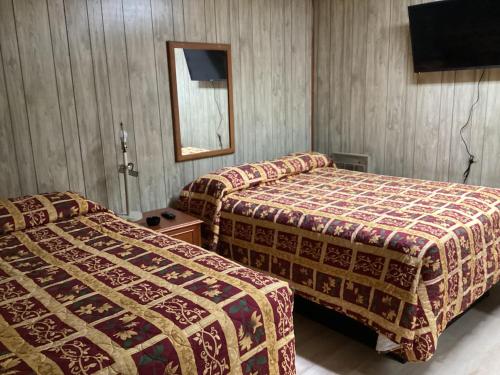 BaxleyPinelodge Motel的酒店客房,设有两张床和镜子