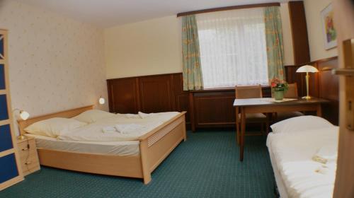 坡瑟利特兹林登克鲁格盖斯豪斯酒店的酒店客房配有两张床和一张书桌