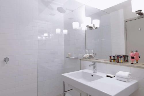 堪培拉堪培拉QT酒店的白色的浴室设有水槽和镜子