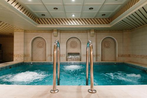 圣彼得堡艾米瑞达格兰德酒店的一个带两个喷水装置的大型室内游泳池