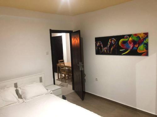 罗安达28A, Lumir Apartamento #8, Luanda的卧室配有一张床,墙上挂有绘画作品