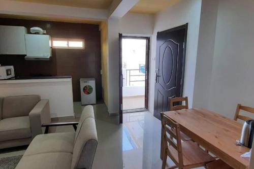 罗安达28A, Lumir Apartamento #8, Luanda的带沙发和桌子的客厅以及门