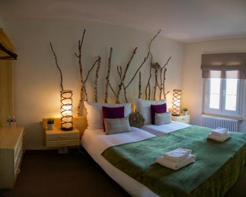 DuillierAuberge de Duillier的一间卧室配有一张大床和两条毛巾