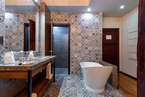 昆卡Hotel La Cofradía Pub-House的一间带大浴缸和水槽的浴室