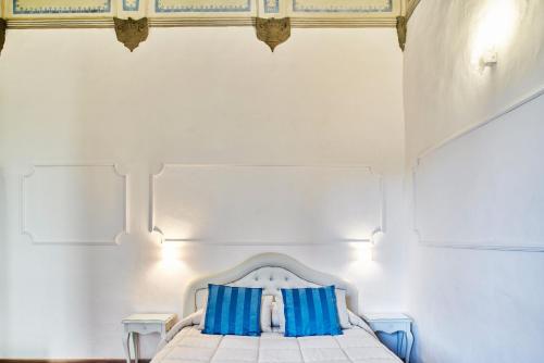 锡耶纳马尼菲科宫殿住宿加早餐旅馆的白色卧室配有蓝色枕头的床