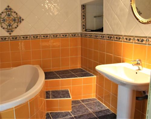 ThilOrangerie LAGAILLARDE的橙色瓷砖浴室设有水槽和浴缸