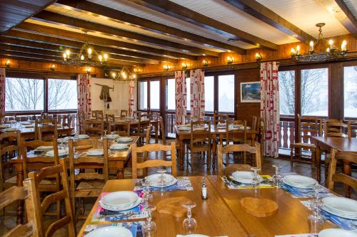 沙泰勒Gîte Châtel的餐厅设有木桌、椅子和窗户。