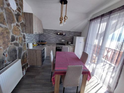 马夫罗沃Tetka Viki的一间带桌子的厨房和一间带石墙的厨房