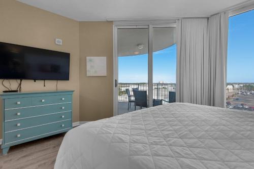 德斯坦Palms Resort #1614 Jr. 2BR的一间卧室配有一张床、一台电视和一个阳台