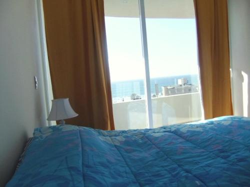 拉塞雷纳Serena Holiday Vista的窗前带蓝色棉被的床