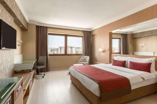 乌沙克华美达乌沙克酒店的酒店客房设有一张大床和一台电视。