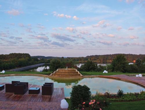 洛斯海姆豪彻沃德沃费勒酒店的享有池塘、椅子和喷泉的景色