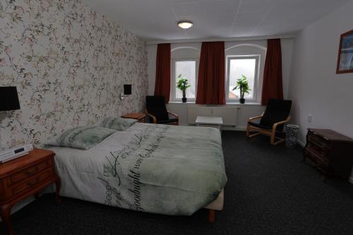 库罗阿尔滕堡Haus Stefanie Elvire的一间卧室配有一张床、两把椅子和窗户
